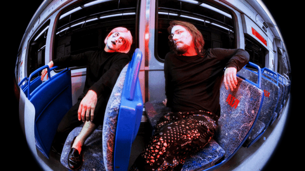 Photo of Radderall & Muzzy Fossa by Lauren Anderson, featuring the duo in moody, surreal lighting that reflects the dreamlike, analog-psych textures of their new concept album The Club Is Open.