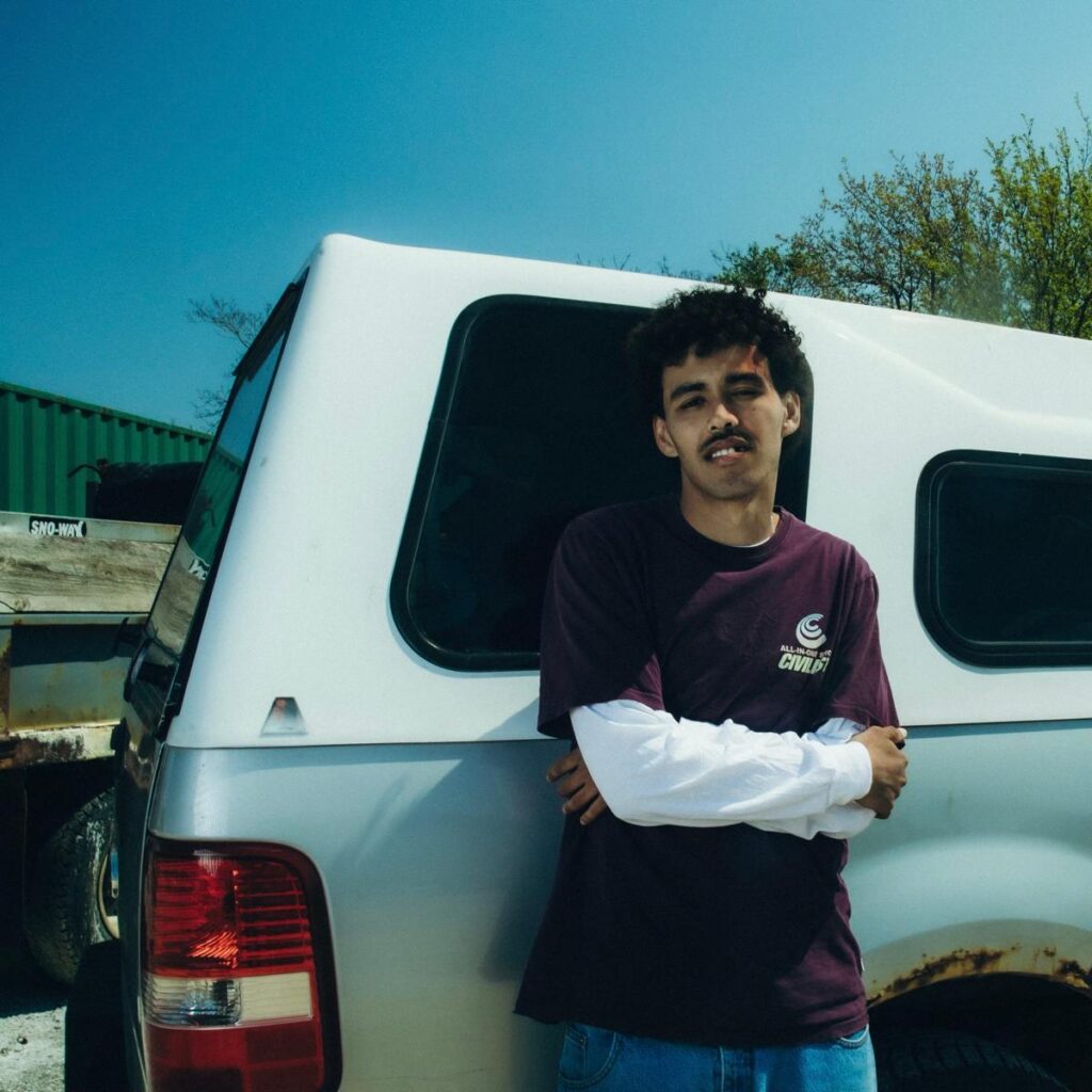 Cam Kahin photographed by Oscar Tam — intense gaze framed by hazy Toronto light, raw and unfiltered.