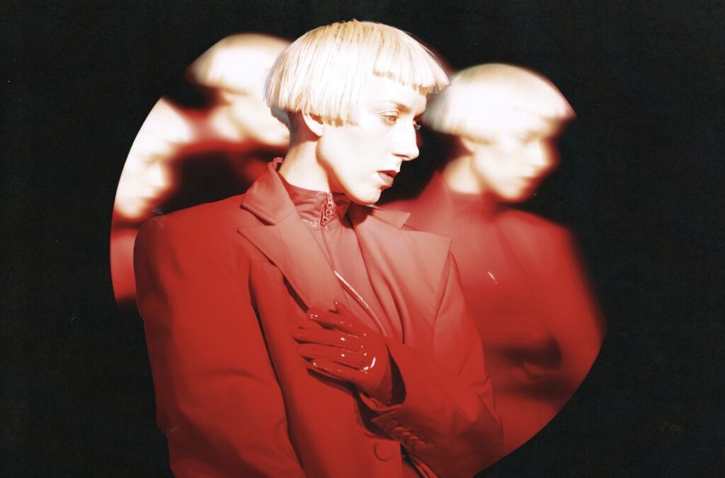 Still from “325” video — red BMW E30 glides through city lights, reflections flickering across chrome.