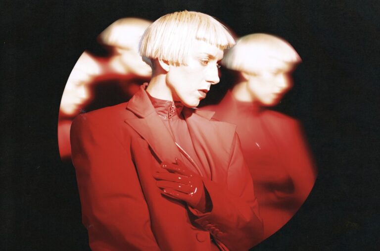 Still from “325” video — red BMW E30 glides through city lights, reflections flickering across chrome.